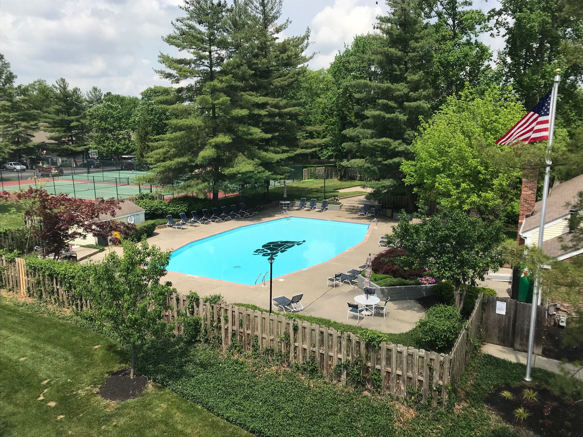 a view of a pool from a backyard with a flag