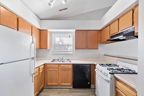 A kitchen with wooden cabinets and a white fridge.