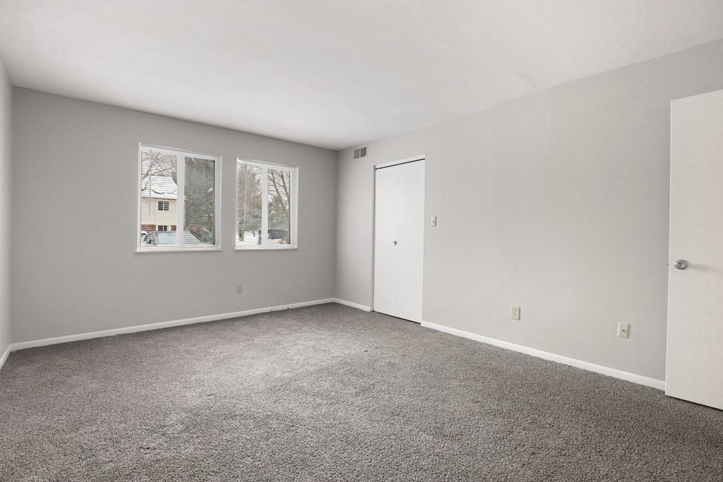A room with grey carpet and white walls.