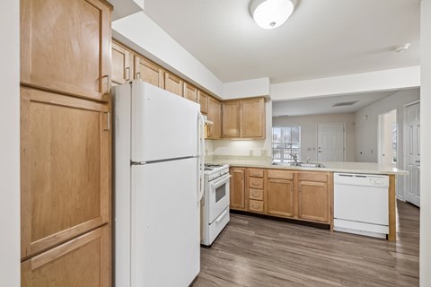 A kitchen with wooden cabinets and a white refrigerator.