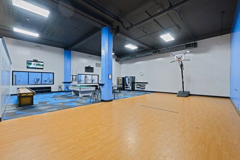 a gym with a wooden floor and a basketball court and a projector