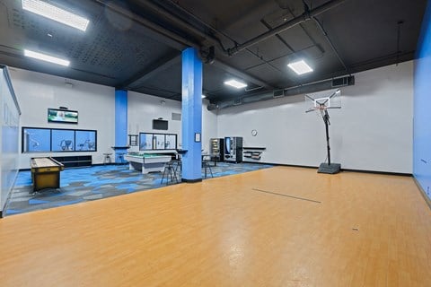 a gym with a wooden floor and a basketball court and a projector