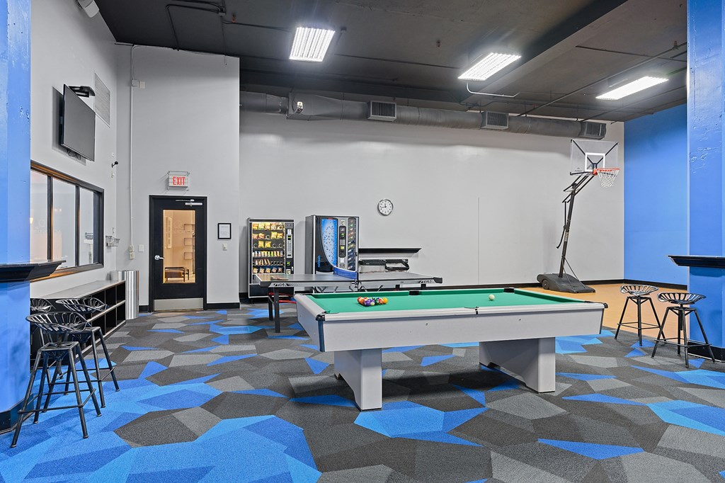 a games room with a pool table and a tv