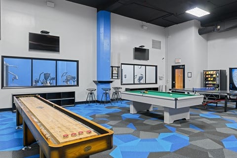 a games room with a shuffleboard table and a pool table
