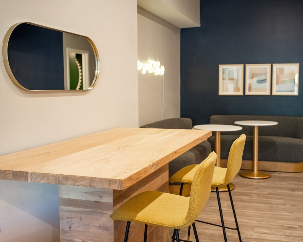 a dining area with a wooden table and yellow chairs