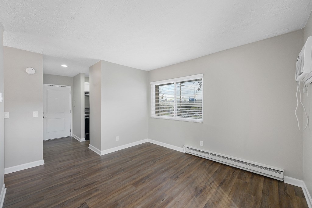 a bedroom with hardwood floors and grey walls