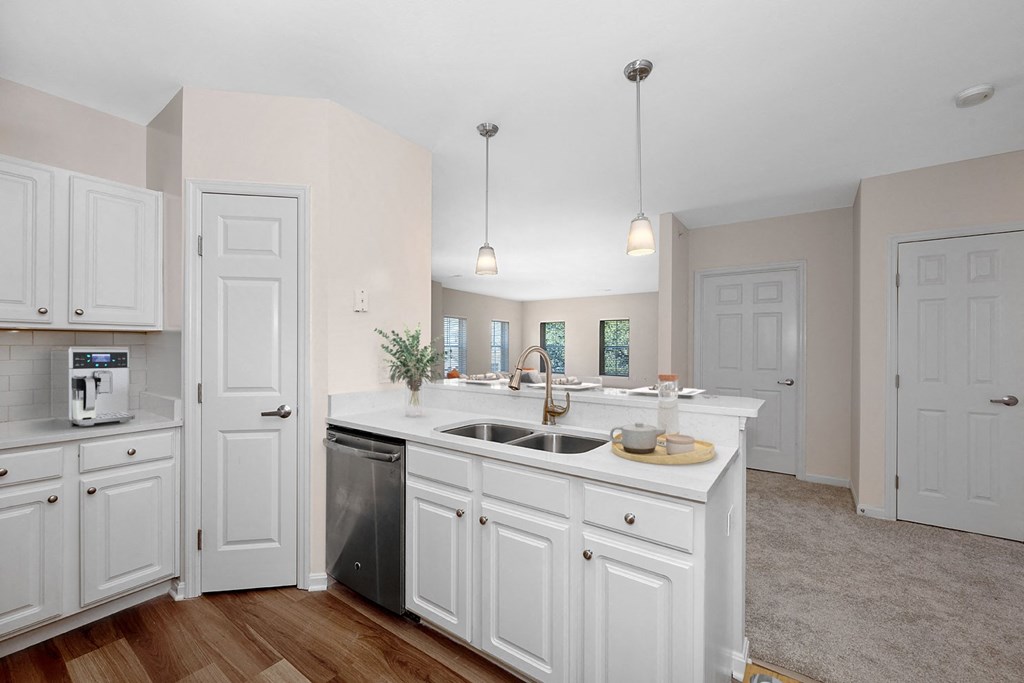 a large kitchen with white cabinets and a sink