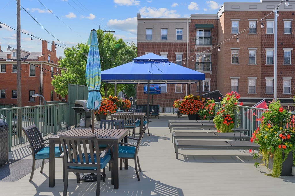 a patio with tables and chairs and an umbrella