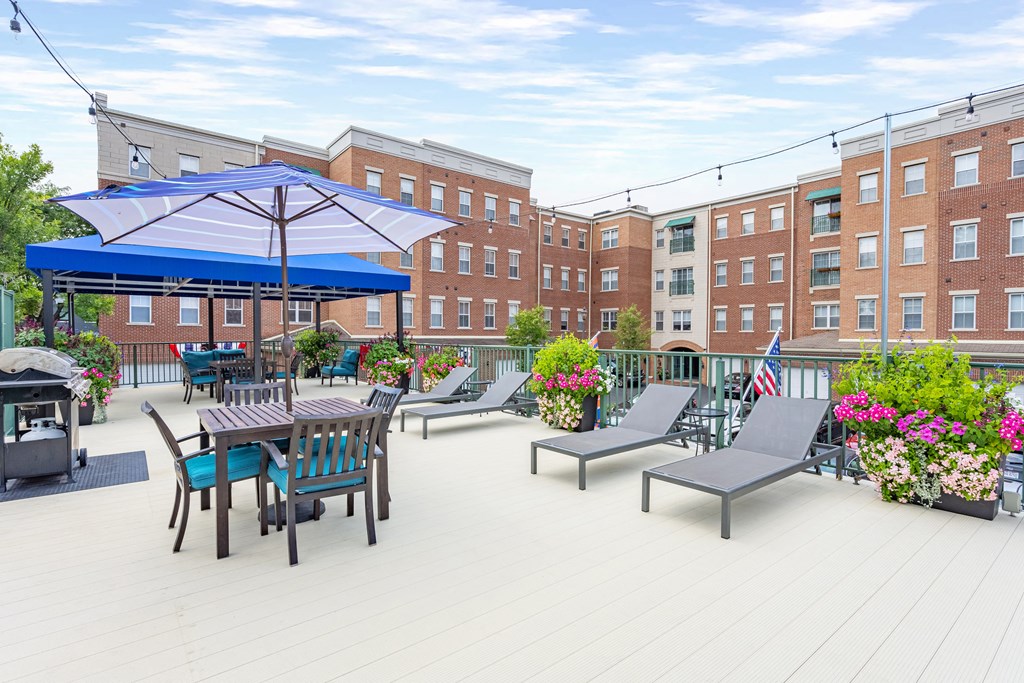 a large patio with chairs tables and umbrellas and a building