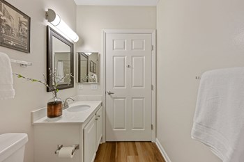 a bathroom with a white sink and toilet next to a white door - Photo Gallery 50