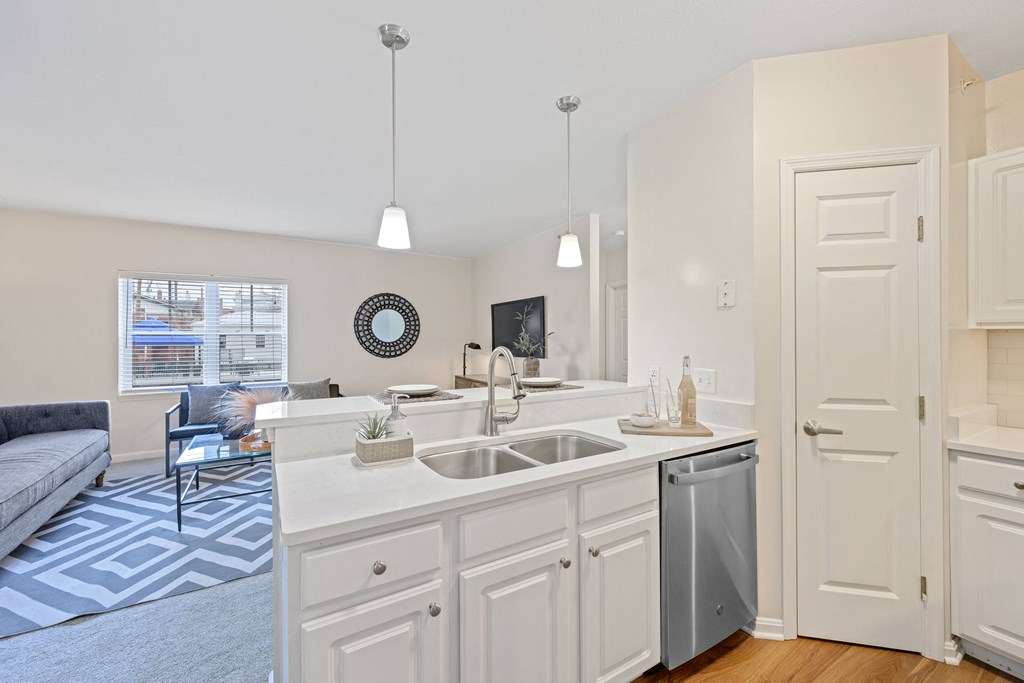 a kitchen with an island and a living room in the background