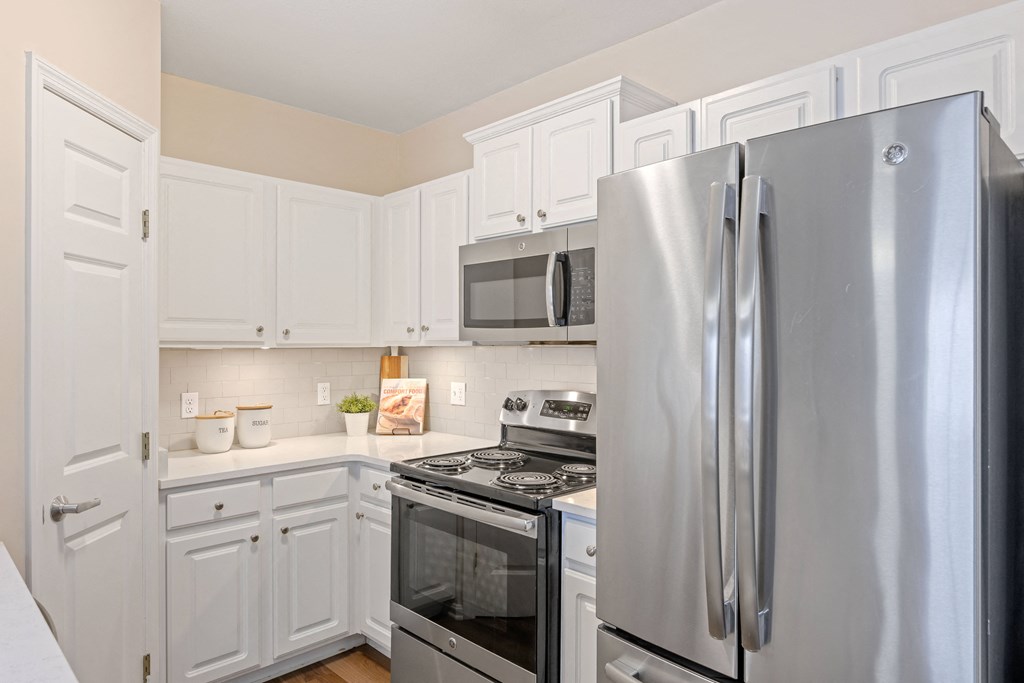 a kitchen with white cabinets and stainless steel appliances