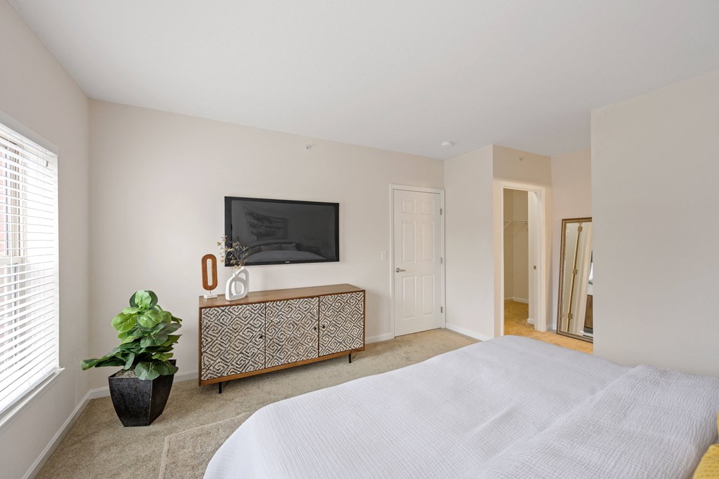 a bedroom with a large white bed and a large window