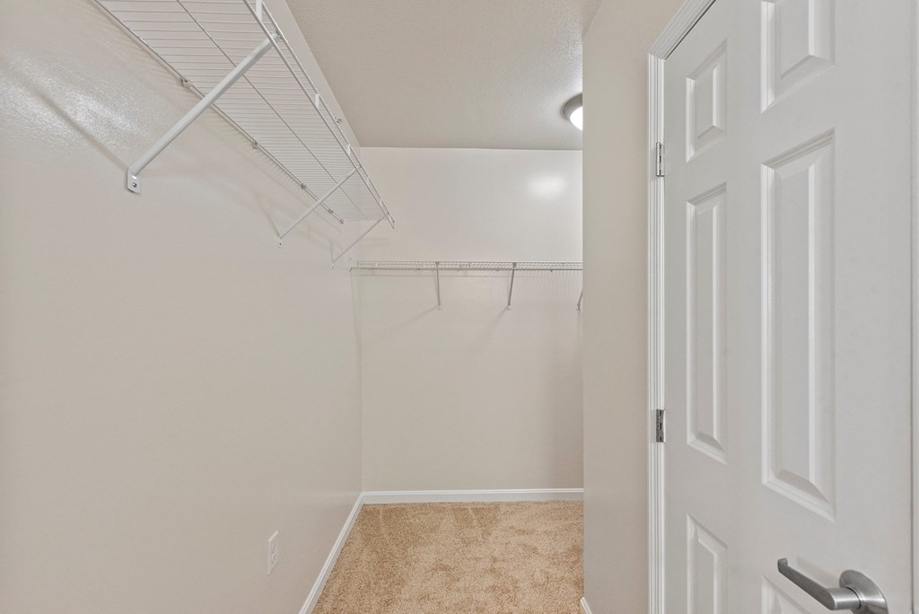an empty closet in a bedroom with white walls and a white door