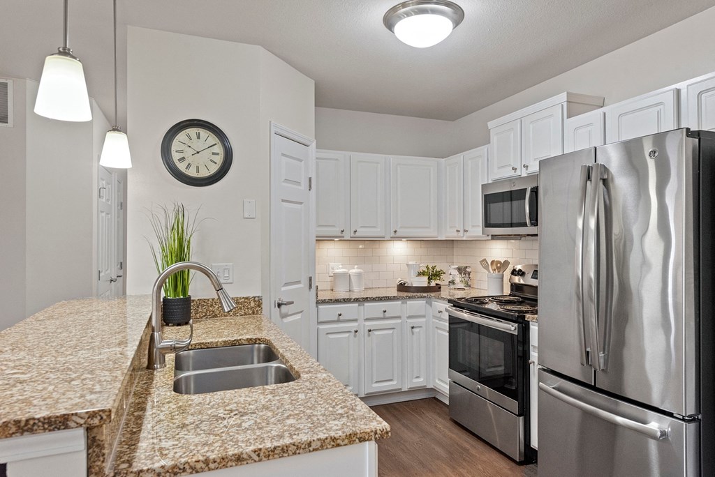 a kitchen with granite counter tops and stainless steel appliances