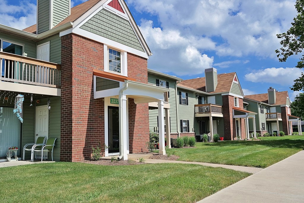 a row of houses with lawns and a sidewalk