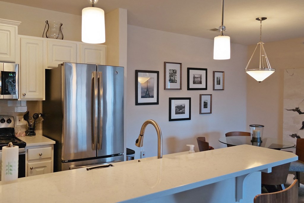 a kitchen with a large counter top and a stainless steel refrigerator