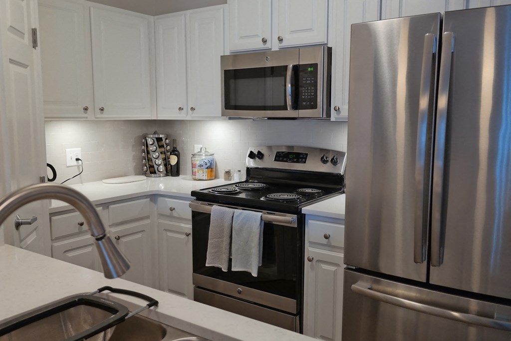 a kitchen with stainless steel appliances and white cabinets