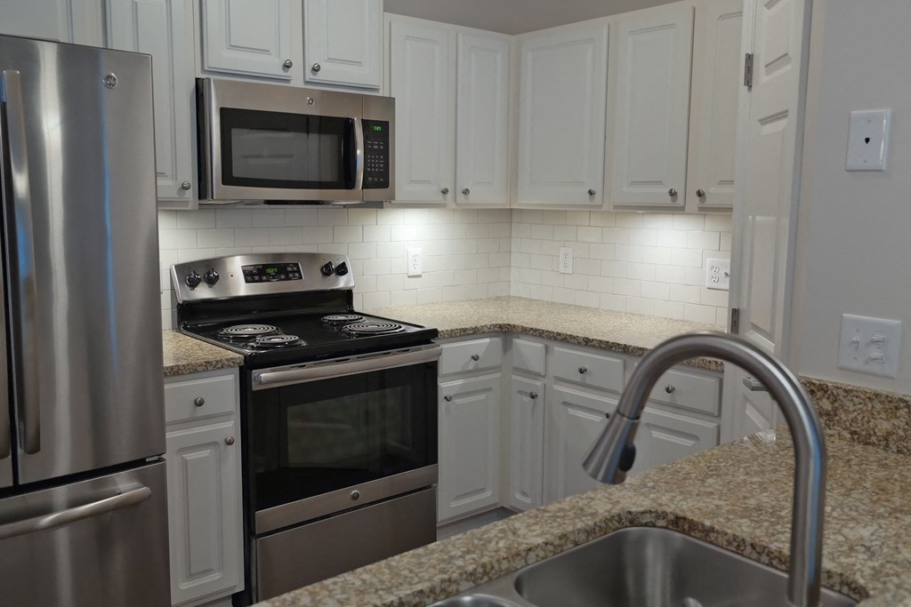 a kitchen with granite counter tops and stainless steel appliances