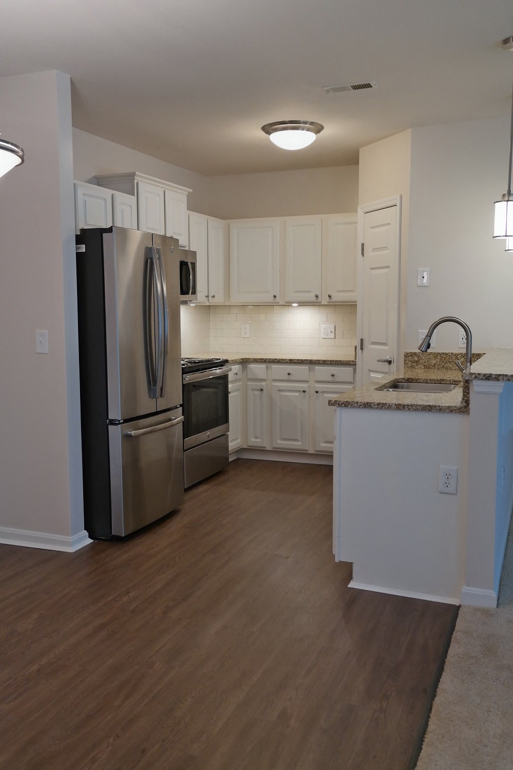 a kitchen with stainless steel appliances and white cabinets