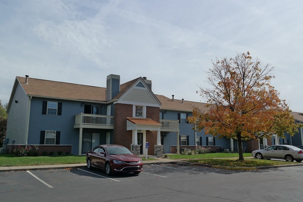 an apartment building with a car parked in front of it