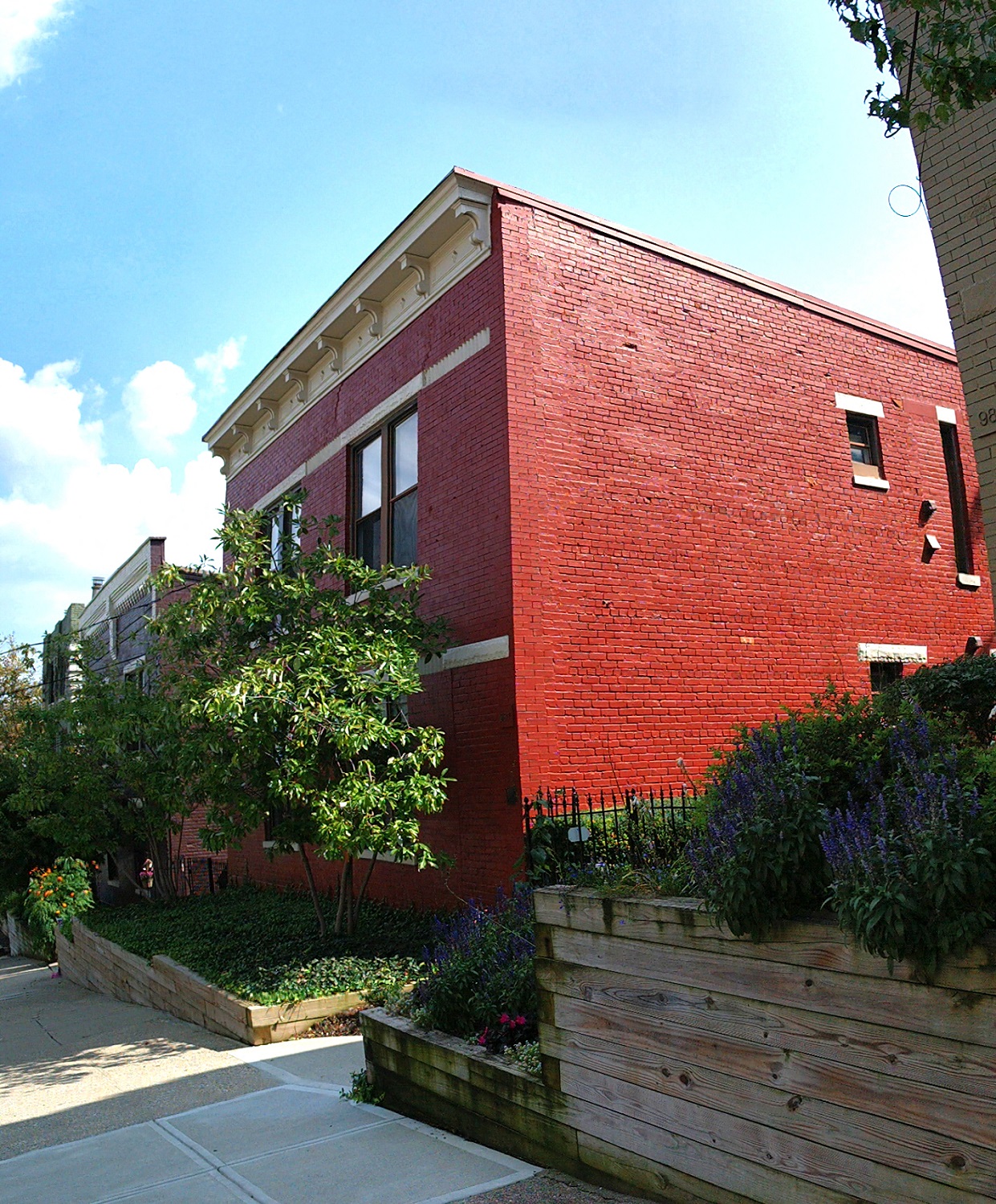 a red brick building with a garden in front of it