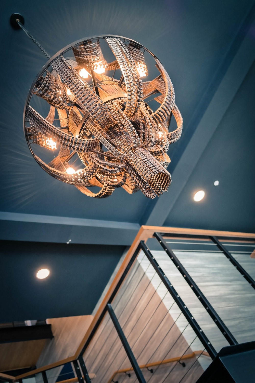 a chandelier hanging from a blue ceiling with a glass window