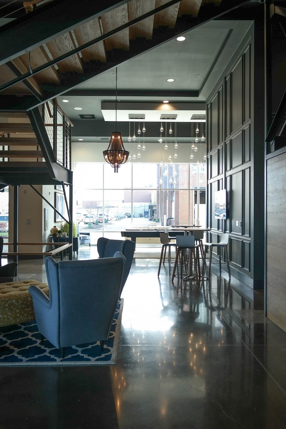 a living room with blue chairs and a table in a lobby