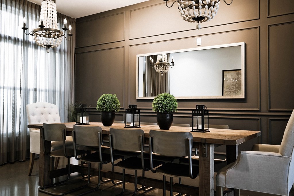 a dining room with a table and chairs and a mirror