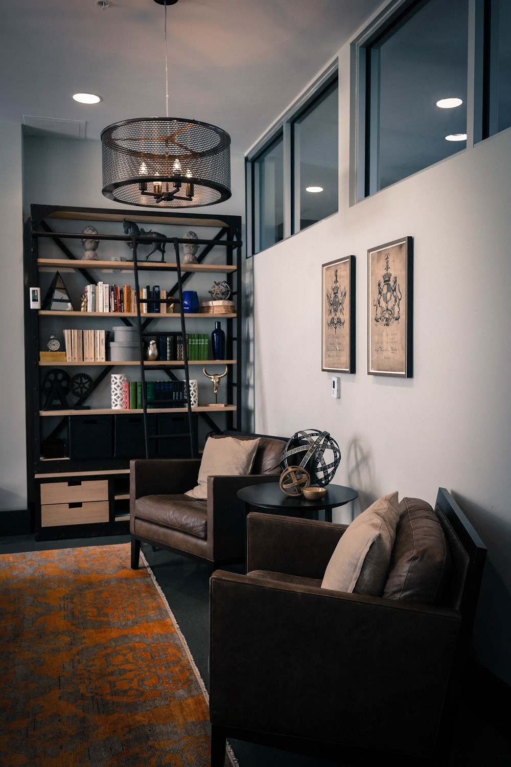 a living room with a couch and chairs and a book shelf