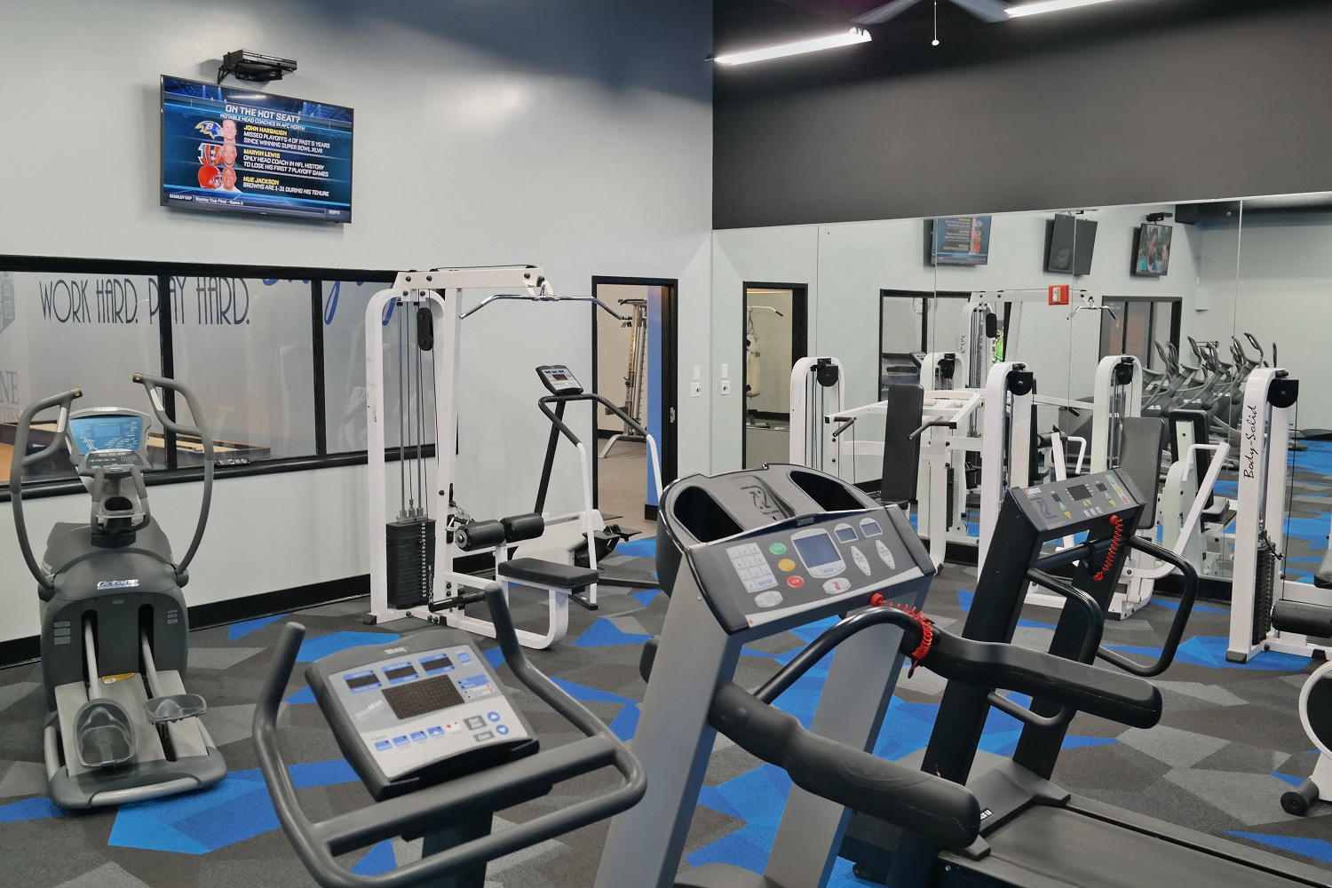 a gym with various cardio machines and weights