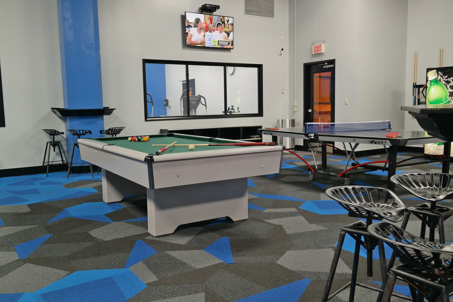 a game room with a pool table and tables