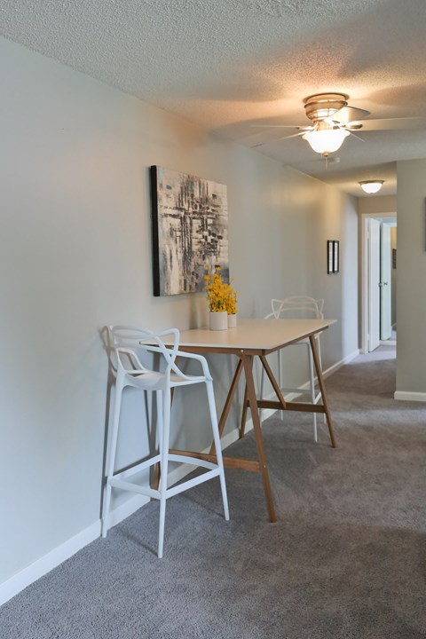 a dining area with a table and chairs and a ceiling fan