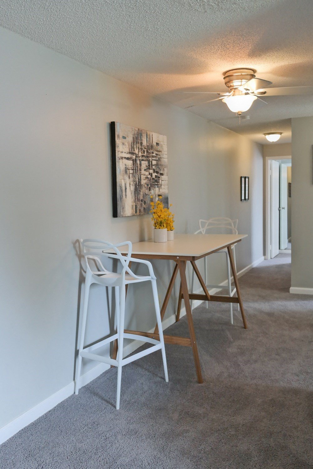 a dining area with a table and chairs and a ceiling fan
