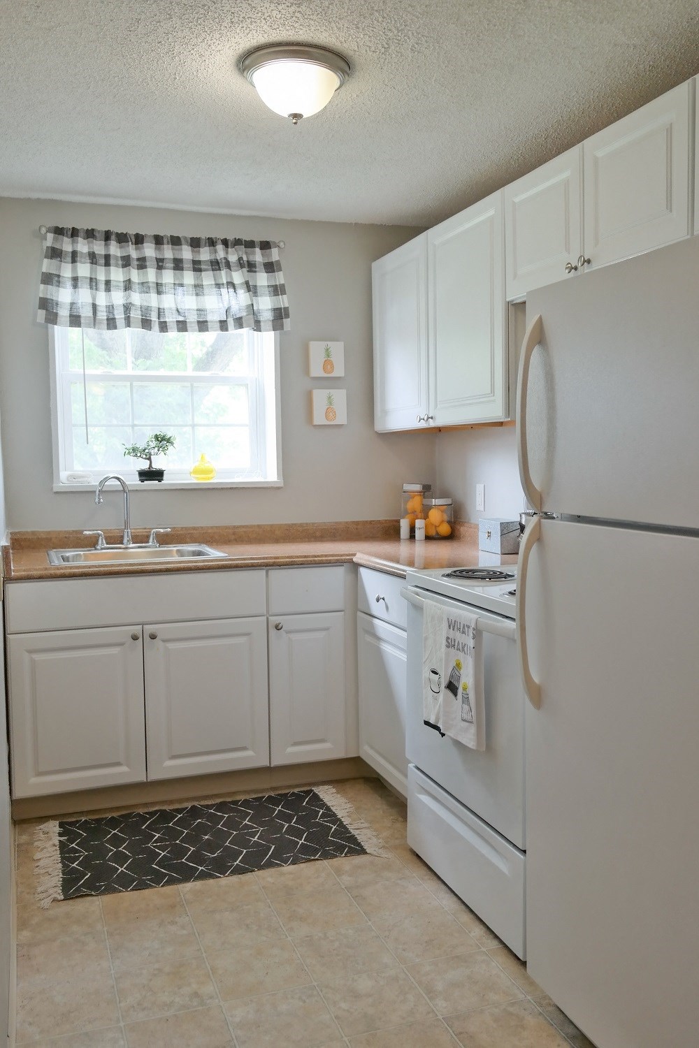 a kitchen with white cabinets and a sink and a refrigerator