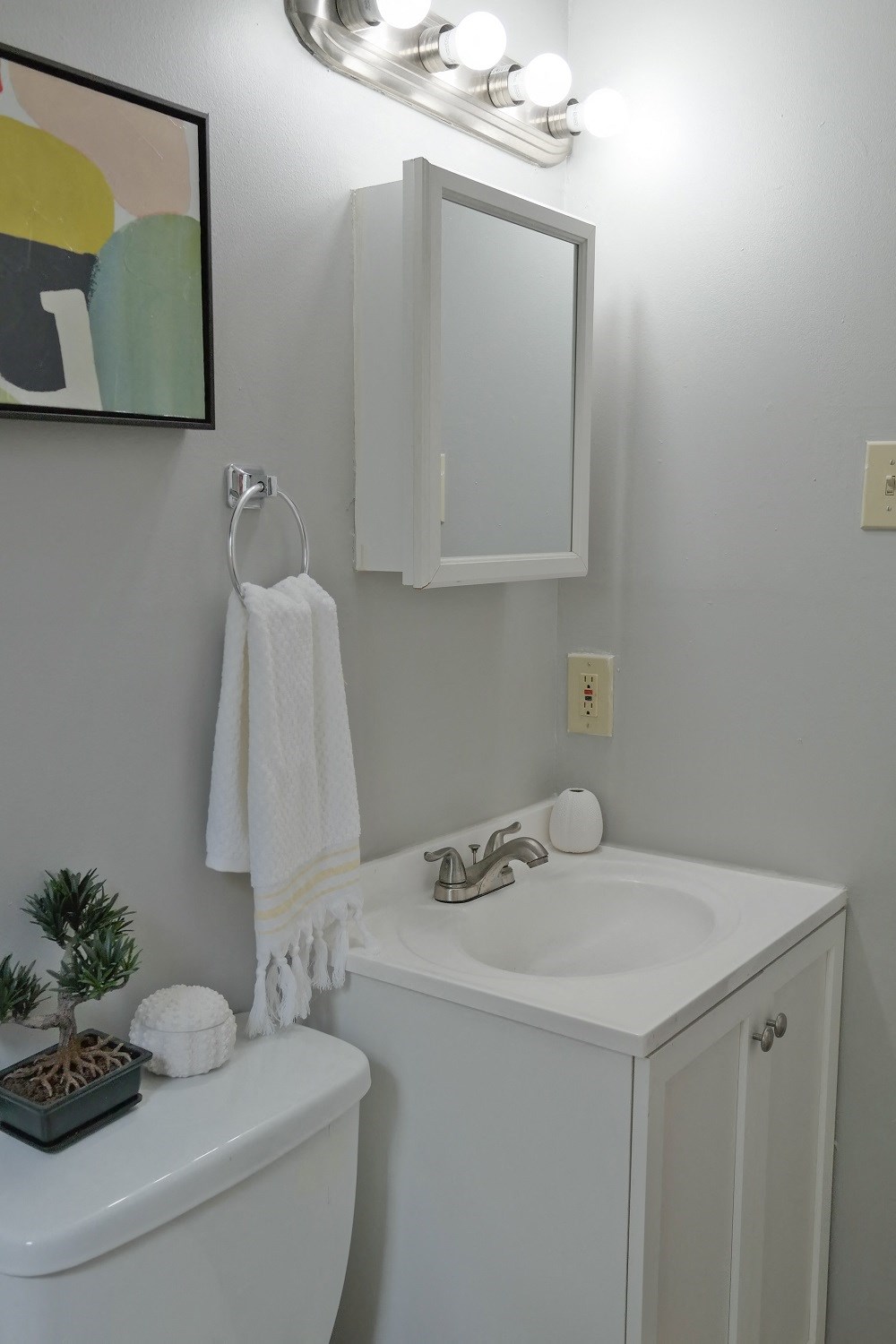 a small bathroom with a sink and a mirror and a towel