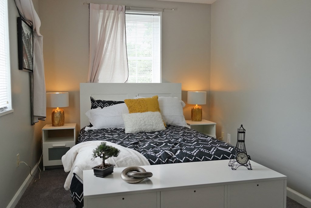 a bedroom with a white bed and a black and white comforter