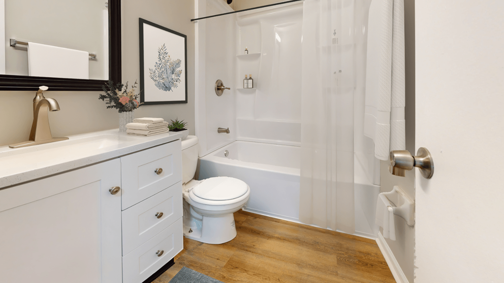 a bathroom with a shower and a toilet and a sink at Stonebrook of Franklin, Franklin