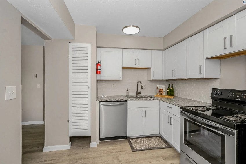 a kitchen with white cabinets and a stove and a sink