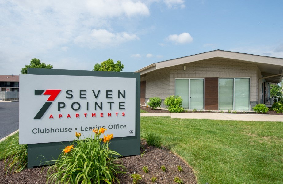 a building with a 7 seven pointe apartments sign in front of it