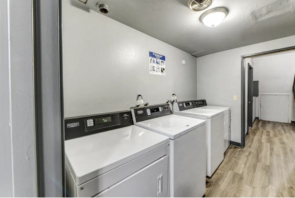 a laundry room with four washers and two dryers