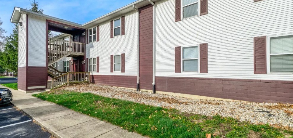 a white and brown apartment building with a sidewalk in front of it at Ridgeview, Indiana, 46040