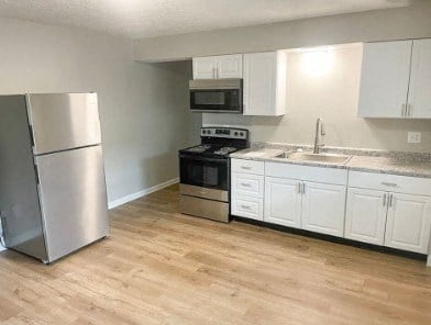 a kitchen with stainless steel appliances and white cabinets