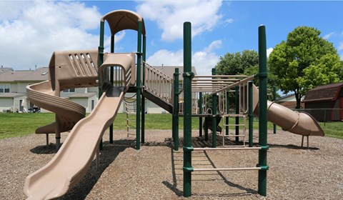 A playground with a slide and a climbing frame.