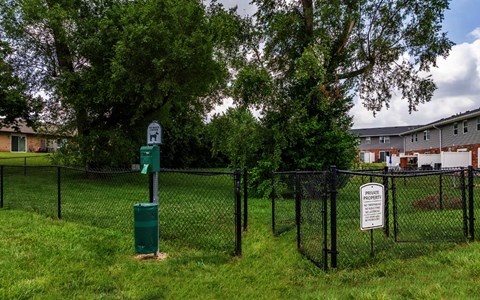 A sign in a green post in a grassy area.
