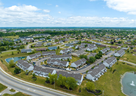 A bird's eye view of a residential area with houses and a swimming pool.