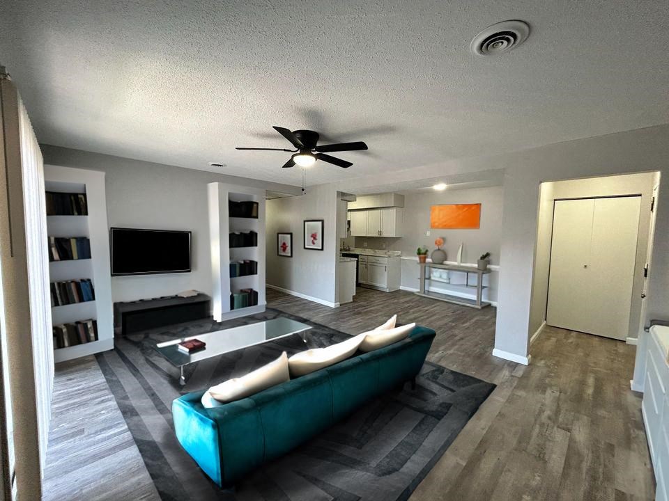 a living room filled with furniture and a ceiling fan