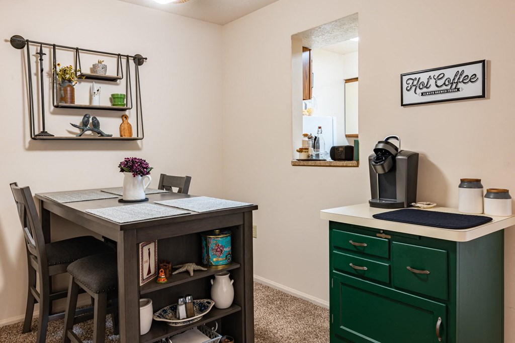a kitchen with a desk and a green cabinet and a mirror