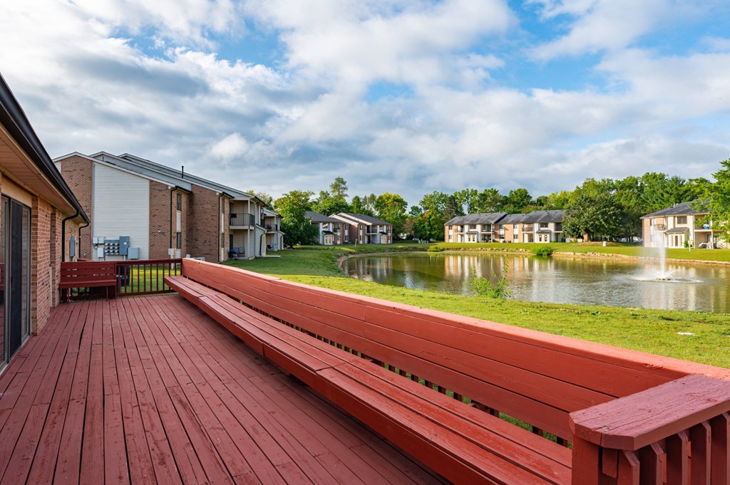 a picnic bench on a deck next to a pond