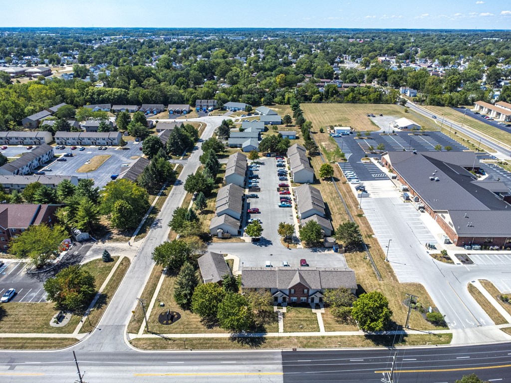 A bird's eye view of a residential area with houses, roads, and trees.
